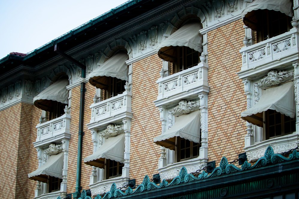 The ornate brick and tile facade of a historic bathhouse with arched balconies on Bathhouse Row in Hot Springs